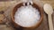 Sea mineral coarse rough salt. Falling into a wooden rustic bowl