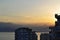 Sea and mountains on sunset with a roof of multy storey house on foreground