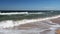 Sea or ocean, surf on a sandy beach. Clear sunny day and blue sky.