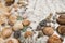 Sea pearl in the center of the frame,  stones and shells lying on a marble background, composition of sea stones and seashells, ma