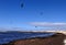 Sea with people parachuting over it in the bright skyline