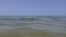 Sea ripples, swimmers and boat on horizon