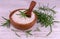 Sea salt with crushed rosemary in a wooden bowl, fresh herbs, vintage white wooden background, selective focus