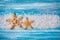 Sea salt crystals and starfishes on blue background