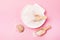 Sea Salt Crystals in White Bowl in Shape of Shell Small Wooden Scoop with Sea Salt and Shell Pink Background Copy Space