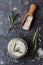 Sea salt scented herb rosemary on black stone background