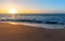 Sea sand and sky at sunset - horizontal background banner. Summer background with evening beach at sunset with waves, clouds -