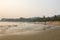 Sea sandy beach against the backdrop of people swiming and the green jungle in the evening