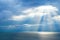 Sea scape under a dense cloudy sky with rays pushing through