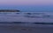 A Sea scene of a the sea Groynes with a sea water splashing against them as they down the pebble beach and disappear