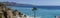 Sea shore with beach and palm tree in Nerja, Spain - panorama