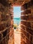 Sea shore bech view through ancient brick wall loophole