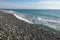 Sea shore with pebbles. wet sea pebbles on the beach and quiet sea surf