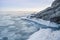 Sea slush and ice floes on the sea surface in winter during sunset.