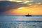 sea and speedboat over cloudy sky and sun during sunset in Cozumel, Mexico