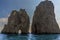 Sea Stacks and a natural arch of the Faraglioni rocks silhouetted against the early morning sunshine on the eastern side of the