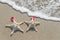 Sea-stars couple in santa hats on the sand.