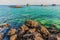 Sea stones and fishing boats floating on sea