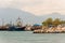 Sea stones marina, touristic and fishermen boats and ships in small bay, city attractions and Olympus mount on the background