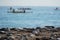 Sea stones on the shore against the background of a kayak