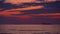 Sea sunrise with dramatic clouds and burning sky and sailing fishing boats and cargo ships in the water