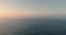 Sea sunrise, flying seagulls and sailing cargo ship against in foggy morning. Aerial 4K video