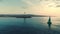 Sea sunrise, sailing cargo ship in the water and lighthouse