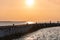 Sea sunset over baltic pier. Dreams of travel and freedom. Beautiful jetty seascape. Sundown sky and claim weather