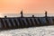 Sea sunset over baltic pier. Dreams of travel and freedom. Beautiful jetty seascape. Sundown sky and claim weather