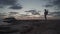 Sea sunset view. Man with backpack on rocks with beautiful view of Yeronisos Island near coast of Agios Georgios Pegeias