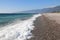 Sea surf rolls onto the shore of a rocky beach in Abkhazia