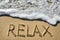 Sea surf and the word relax on the sand