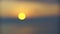 Sea surface small waves against golden slow motion sunrise. Large disk of the sun rises above the sea blurred background