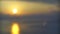 Sea surface small waves against golden slow motion sunrise. Large disk of the sun rises above the sea blurred background