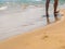 Sea transparent net wave washes the legs of a tourist