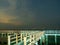 Sea view near mangrove forest with man made wooden barrier for wave protection, under starry nigh cloudy sky