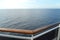 Sea view from the open deck of a modern cruise ship, railing and strong glass wall.