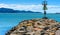 A sea wall in the foreground, blue water and tropical island in the distance