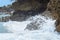 Sea water hitting stones background. Rough seas in beach Coqueirinho