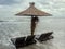 Sea water on seaside with sunbeds and straw umbrella, sand and blue sky, cloudy day