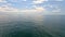 Sea water surface. Aerial view on calm water surface, camera flies over clear sea ocean. Sun glare. Abstract nautical