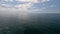 Sea water surface. Aerial view on calm water surface, camera flies over clear sea ocean. Sun glare. Abstract nautical