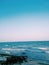 Sea wave with Blue sea and clearly sky. Evening light. Rock beach.