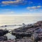 Sea wave breaks about boulders