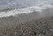 Sea wave with foam on the shore with pebbles. background, banner, summer, travel