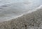 Sea wave with foam on the shore with pebbles. background, banner, summer, travel