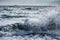 Sea wave splash on stormy day with a ship on a horizon background. Pontecagnano beach, Italy