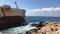 The sea waves beat against the abandoned merchant ship in the Cyprus. View of the crystal clear sea, layered rocks and beautiful n