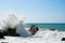 Sea waves bouncing onto rocks creating shower of water droplets