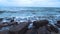 Sea waves break on the rocky stones on the beach. Seascape, storm view from the shore. Cloudy day. HD video